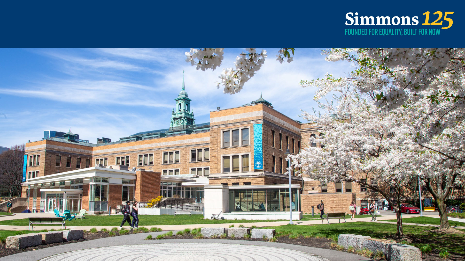 A Zoom background for the Simmons 125th Anniversary featuring a photo of the Simmons University campus with trees in bloom