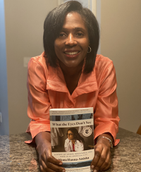 Lynn Perry Wooten holding "What the Eyes Don't See" by Dr. Mona Hanna-Attisha