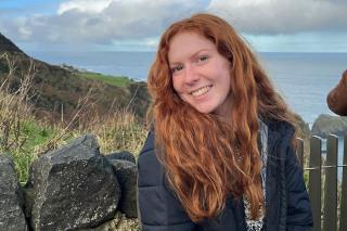 Gracyn Delaune ’24 poses with the coastline of Ireland in the background