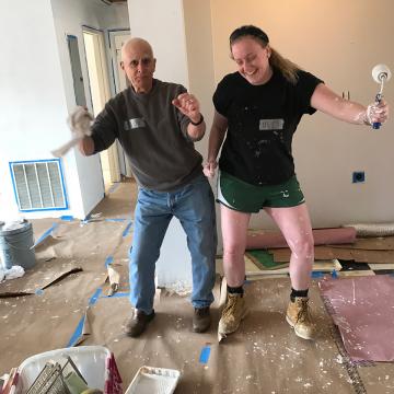 Mary Soares '19 and John, a volunteer with the Pickens County Habitat for Humanity Chapter, dancing at a worksite.