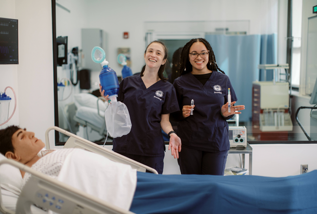 Two Simmons students in the Nursing simulation lab