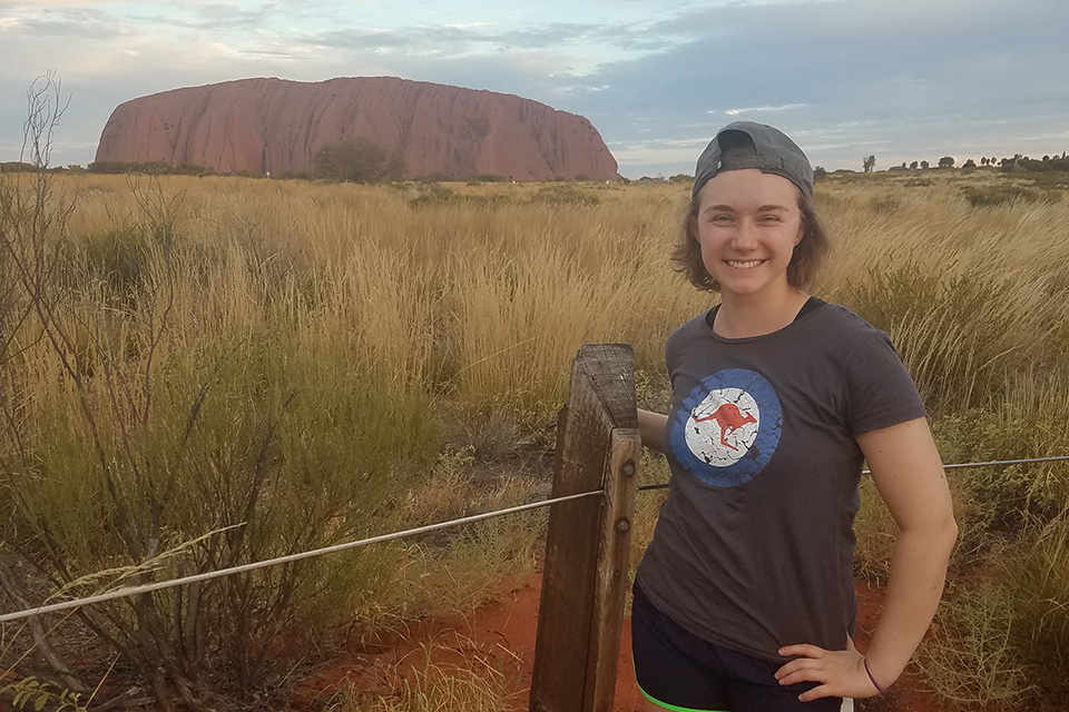 Christina Zahaerevich standing in front of Uluru in Australia