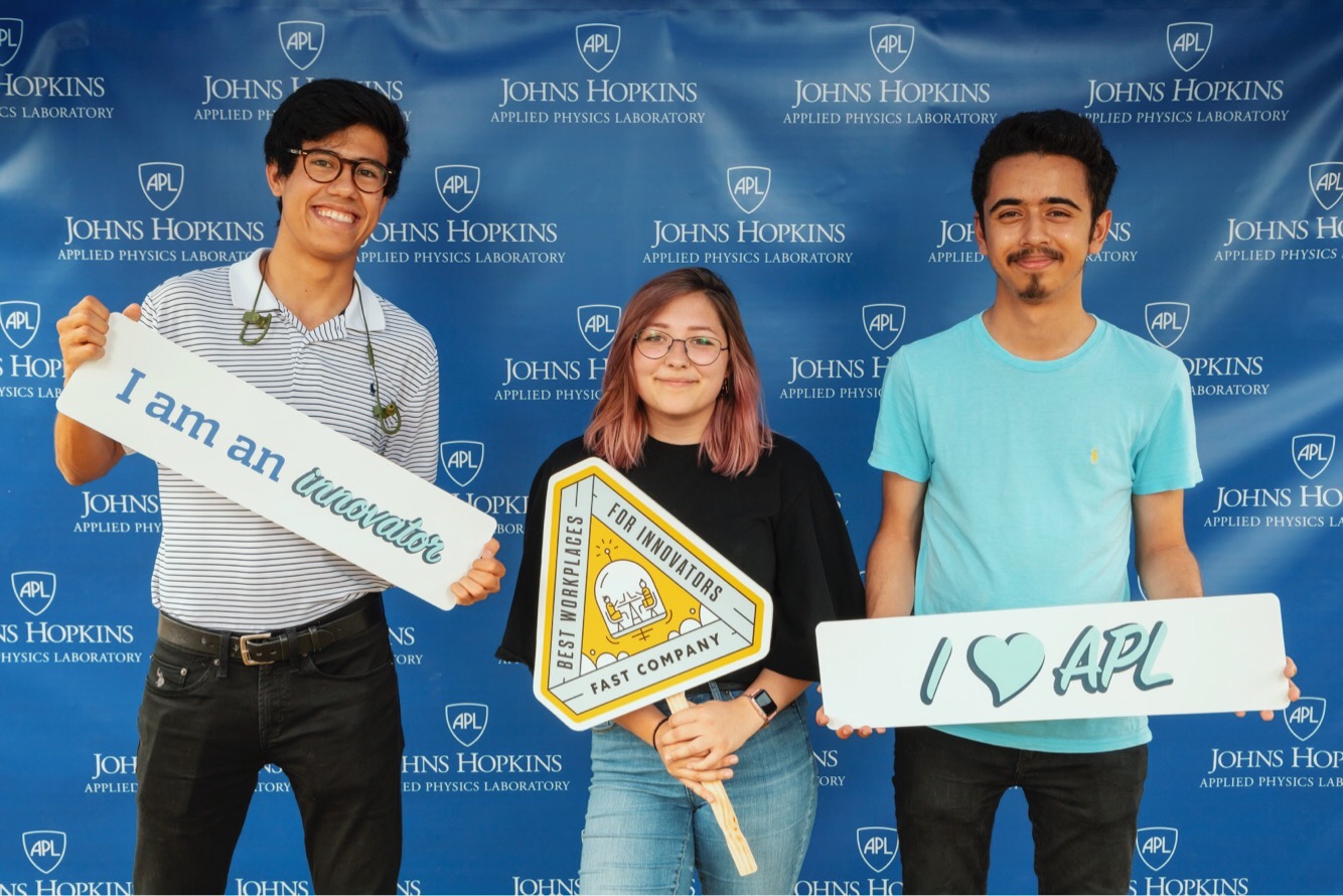 Lauren Wagner and two of the interns she worked with, Camilo Cedeno-Tobon and Aadil Islam at an APL event