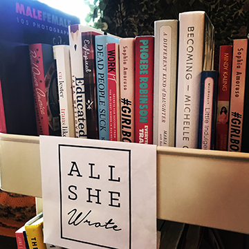 A cart filled with books at an All She Wrote Books pop-up event.