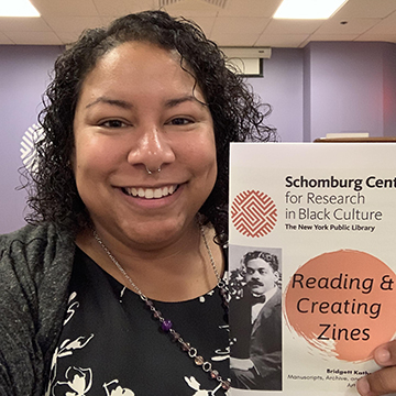 Bridgett Pride holding her "Reading & Creating Zines" guide