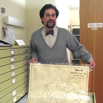 Abraham Schechter holding a map of Portland, Maine