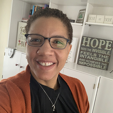 Dr. Renique Kersh in her home office with inspirational quotes in the background
