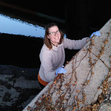 Emma Harrison gathering samples for muddy river project.
