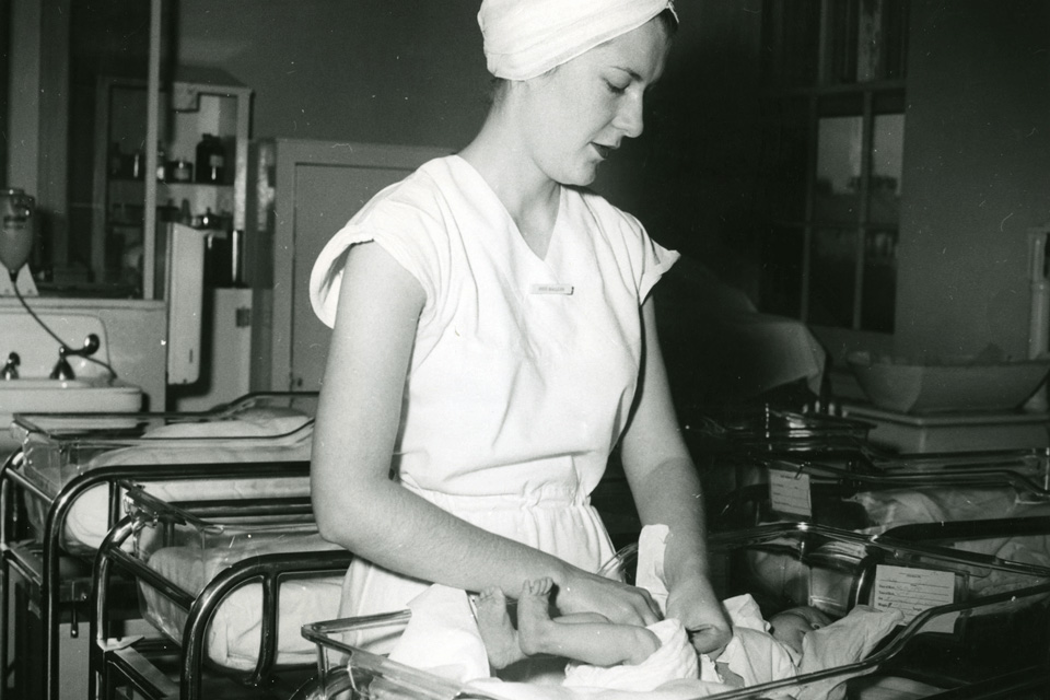 Christine MacLean, Class of 1959, changing a newborn at the Boston Lying-in Hospital.