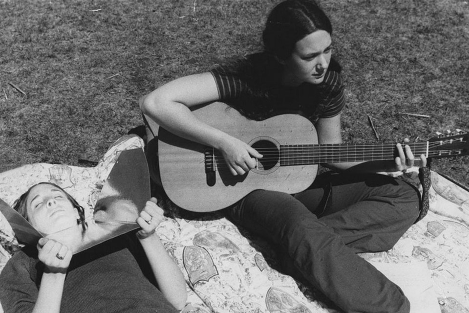 Two unidentified students relaxing on a blanket on the Quad, 1975