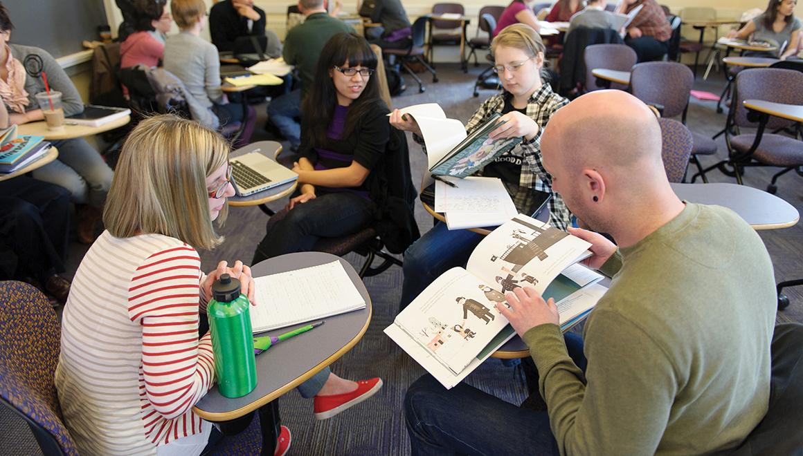 Students sitting in class looking at picture books