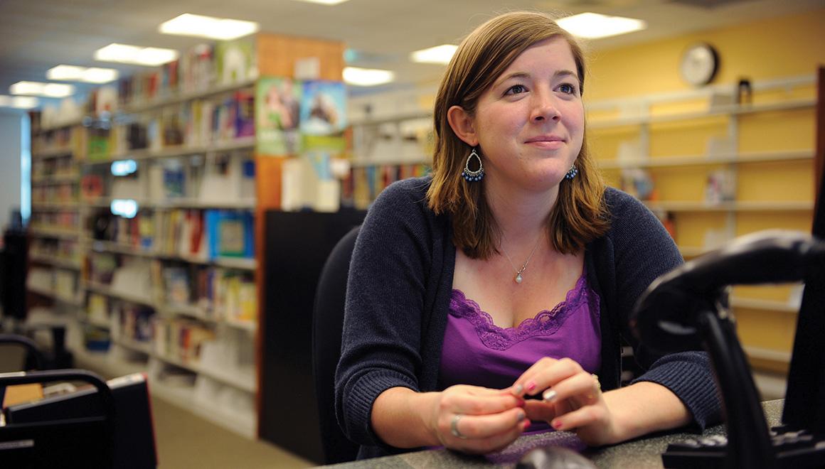 A librarian sitting at her desk