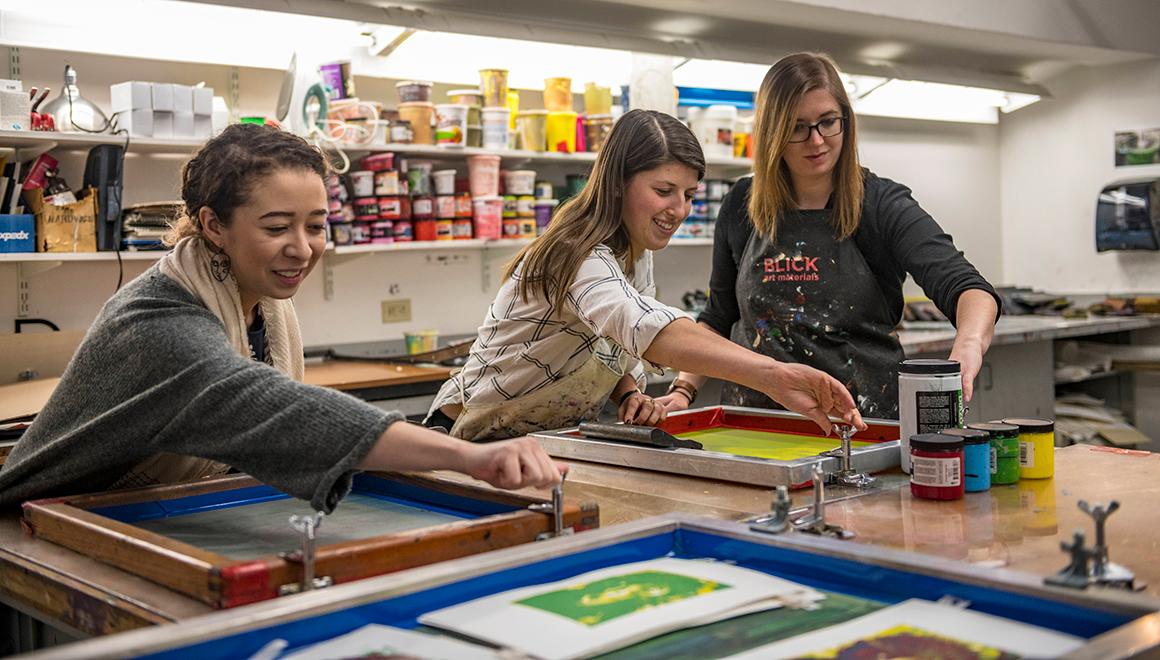 Students screen printing in an art class