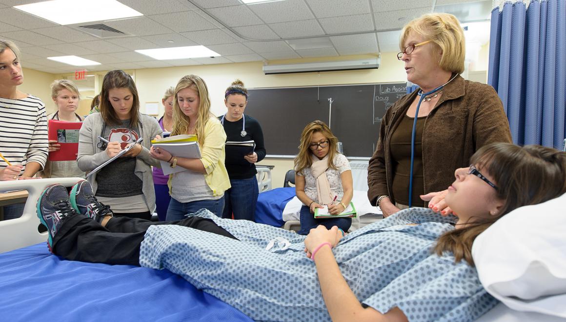 Nursing students examining a mock patient