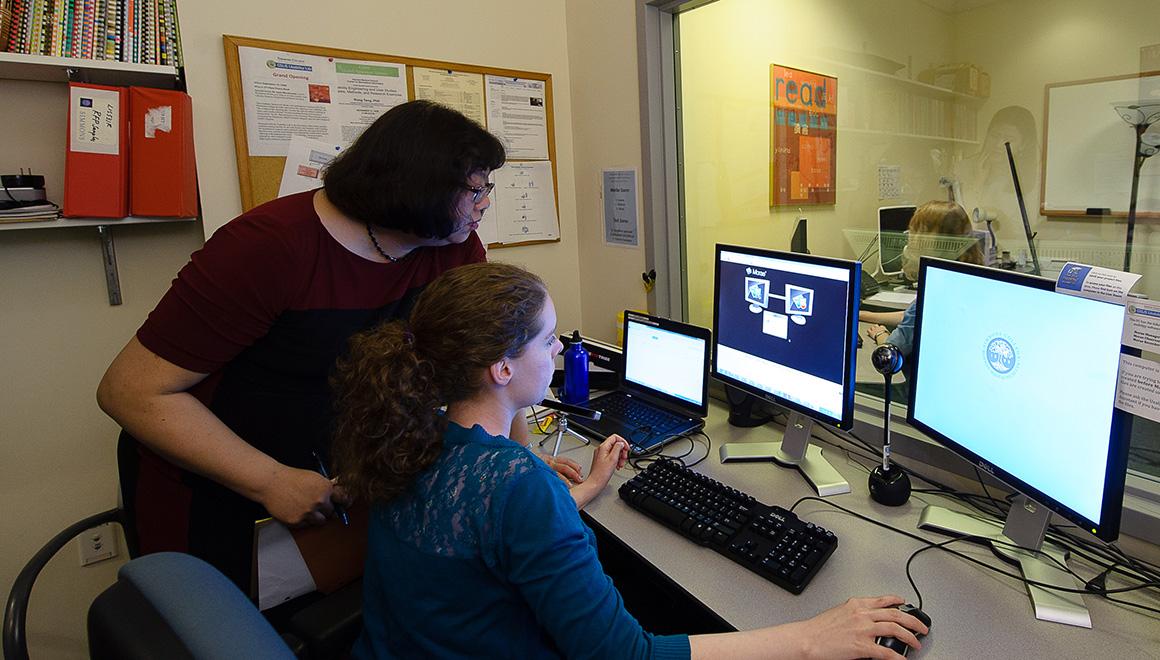 Professor and student working on a computer