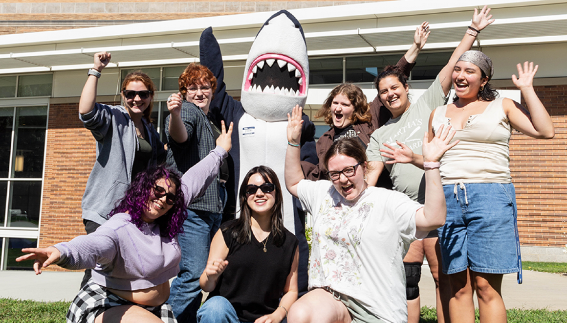A group of orientation leaders and Stormy waving with excitement