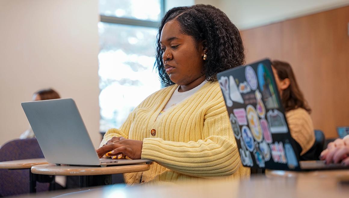 Social Work graduate student on laptop.