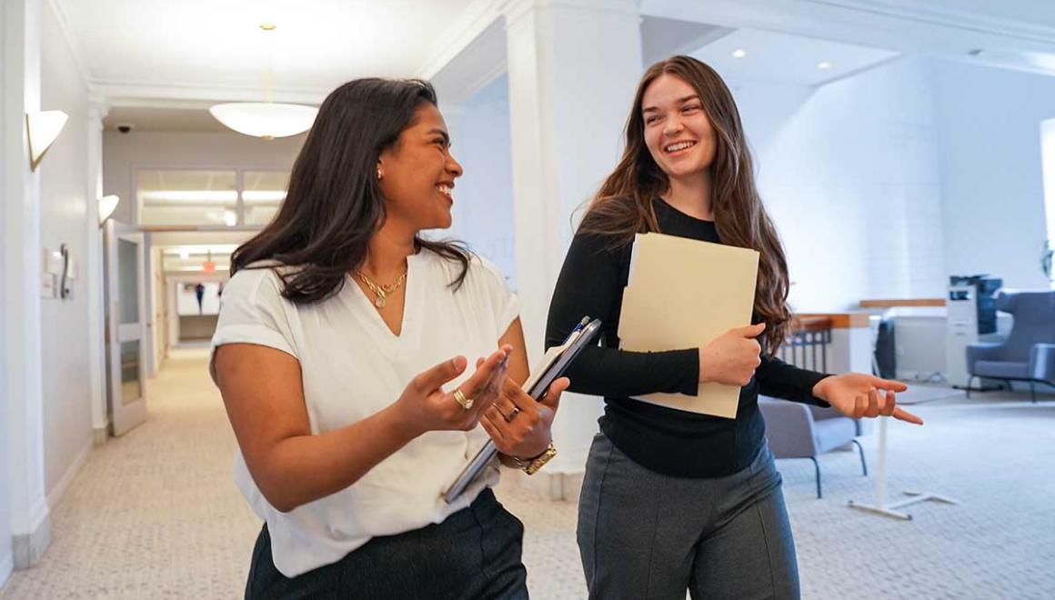 Two Simmons management students walking and talking