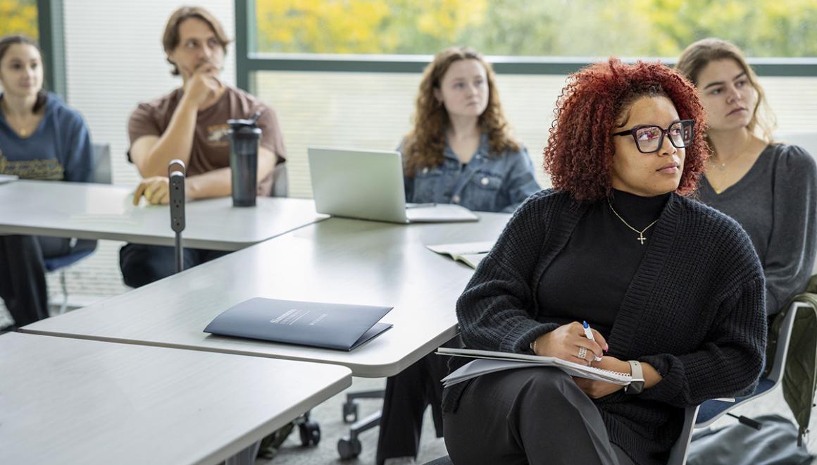 A group of social work students seated in a classroom paying attention to a lecture