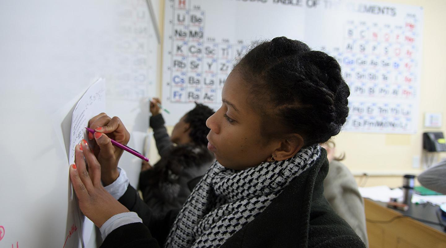 Student writing on a whiteboard