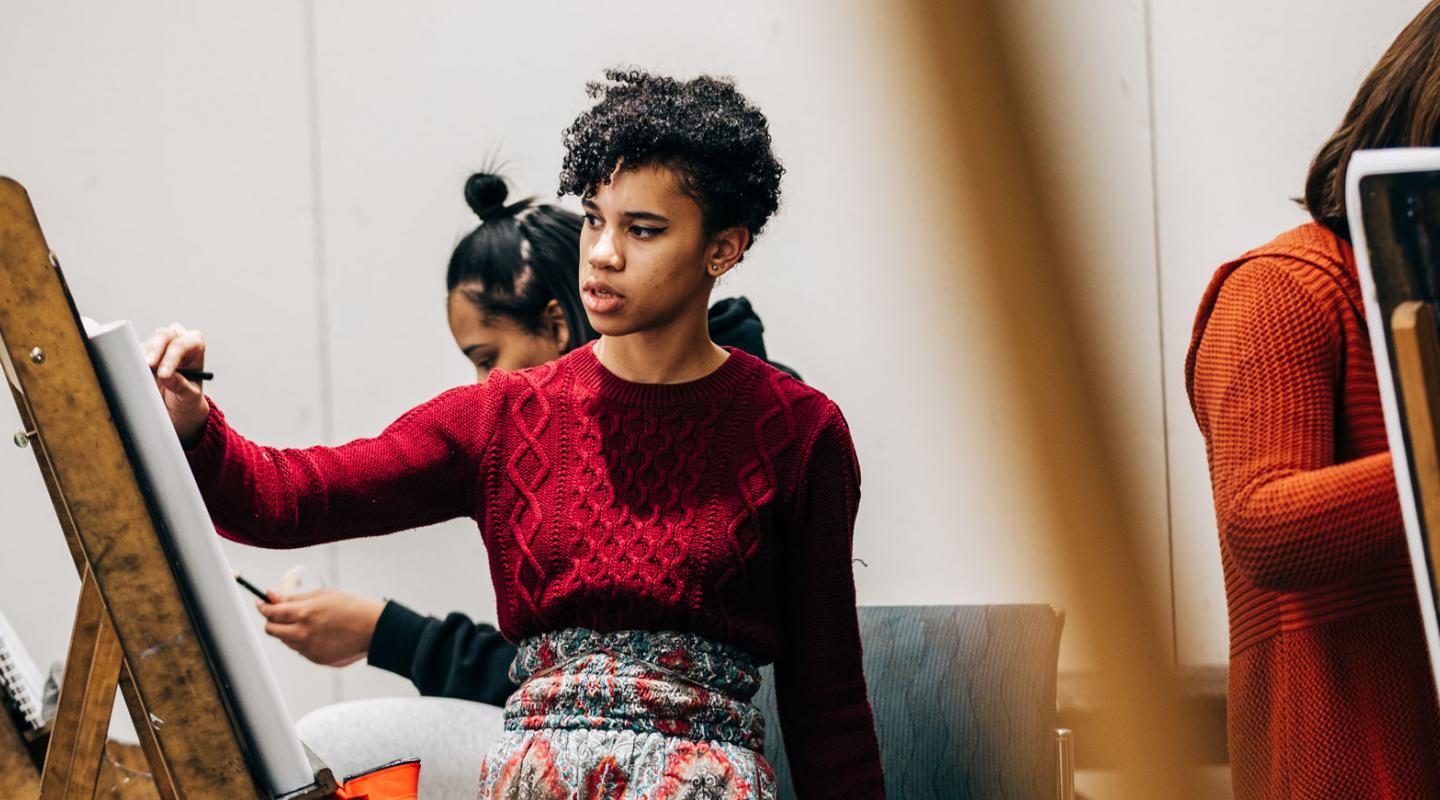 A student painting during an art class at Simmons University