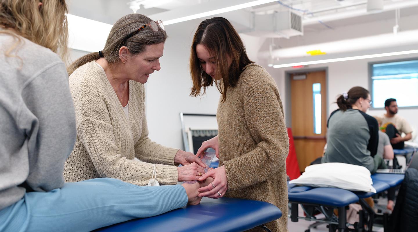 Student and Faculty examining ankle of volunteer patient