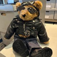 A teddy bear dressed in a black leather jacket