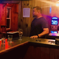 Eric Poulin standing behind the counter at a bar.
