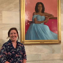 Leslie Calderone ’11MS poses next to the White House portrait of Michelle Obama