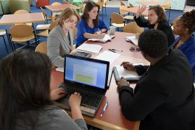 Students sitting around a table in discussion.