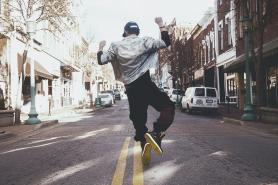 man jumping on the middle of the street during daytime photo
