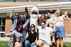 A group of orientation leaders and Stormy waving with excitement