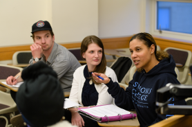 Three graduate students in a classroom at Simmons University