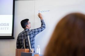 Instructor writing on whiteboard in classroom