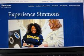 A photo of a laptop displaying the homepage of the Simmons University website