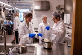 Three Simmons nutrition students in the nutrition lab working on a project involving cheese