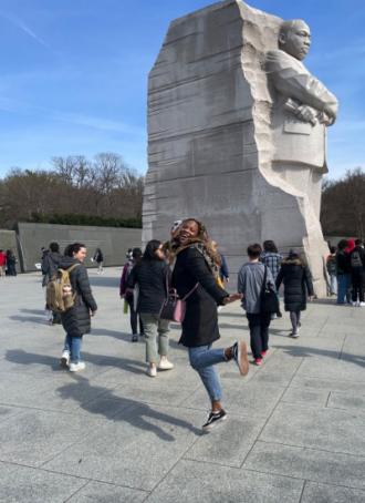 Student smiling in front of MLK Statue on Alternative Spring Break