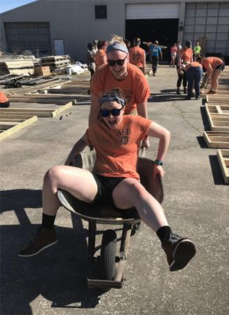 Students having fun with Wheelbarrow during Alternative Spring Break