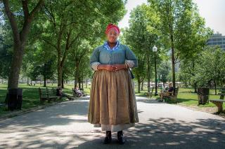 Cheyney McKnight standing in the Boston Common dressed as an enslaved woman.