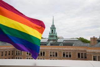 Pride flag waving with Simmons cupola in the background.