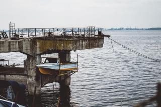 Boat lifted out of water on concrete dock.