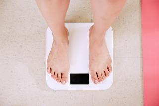 Feet standing on a bathroom scale.