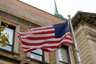 The American flag flying outside the Simmons Main College Building.