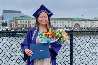 TuQuyen Tran Vo ’22 posing with her Simmons diploma