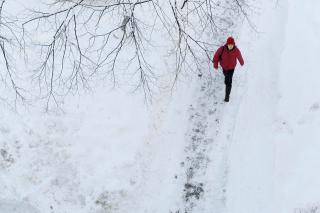 Simmons Student walking on a snowy path