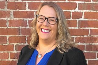 Photograph of Annmary Connor in front of brick wall