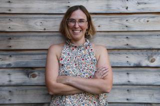 Emily Ostrow ’09MSW leaning against a wall and smiling