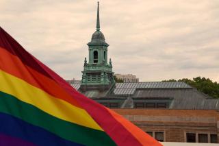 The cupola of the Main College Building on the Simmons campus with a Pride flag in the foreground