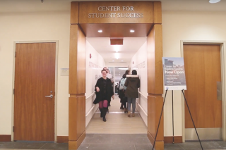 Students walking in the hallway under the sign for the Center for Student Success