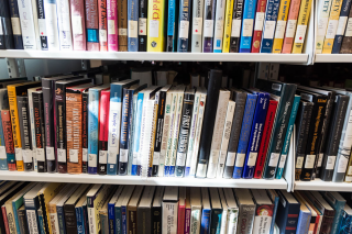 Three shelves full of books in the Simmons University library